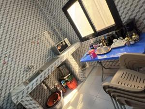 a small bathroom with a shower with a blue table at Studio Meublé in Rufisque