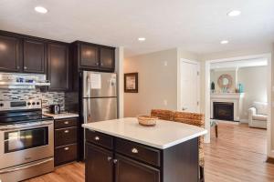 a kitchen with stainless steel appliances and wooden cabinets at Large Great Location Dog Friendly in Dennis