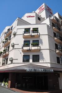 a white building with two balconies and flowers on it at Hotel Terrace Yokohama in Yokohama