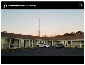 two cars parked in a parking lot in front of a motel at Wolcott inn and suites in Wolcott