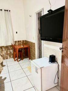 a living room with a flat screen tv on a wall at Pousada Sol Nascente in Morros +12 photos
