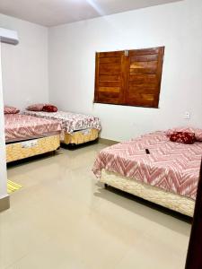 a room with three beds and a cabinet on the wall at Pousada Sol Nascente in Morros