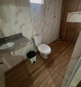 a bathroom with a toilet and a sink at Pousada Sol Nascente in Morros