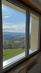 a window with a view of a green field at Soleil Bleu in Saint-Racho