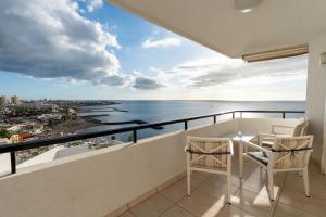 a balcony with two chairs and a view of the ocean at Club Villamar Exclusive Beachfront Penthouse in Adeje