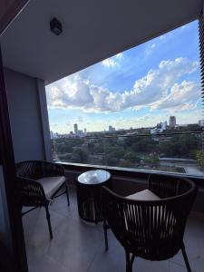 a balcony with two chairs and a table and a large window at Feel Premiun 1203 in Asunción
