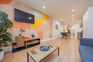 a living room with a couch and a tv on a wall at BILBAO RIVERSIDE by STAYNN APARTMENTS in Bilbao