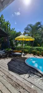 a patio with a yellow umbrella and a pool at Villa Ulutawu in Le François