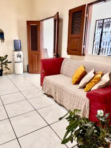 a living room with a red couch with yellow pillows at Pousada Sol Nascente in Morros