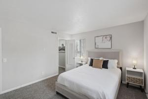a white bedroom with a bed and two lamps at Cozy Downtown Stone Mountain Apartment in Stone Mountain +12 photos
