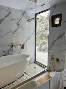 a bathroom with a white tub and a window at Econest Aparan in Aparan