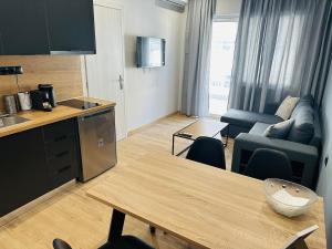 eine Küche und ein Wohnzimmer mit einem Tisch und einem Sofa in der Unterkunft Agatha-4 in Piräus
