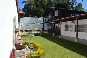 a garden in front of a white building at El Refugio - Hospedaje y Eventos in San Lucas Sacatepéquez