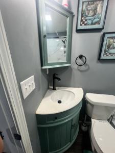 a bathroom with a green sink and a toilet at Cozy Cove in Lithonia