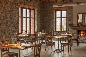 restauracja ze stołami i krzesłami oraz ceglaną ścianą w obiekcie Le Marron w mieście Polikástanon