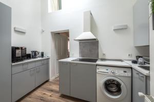 a white kitchen with a washing machine in it at Vienna Antic in Vienne