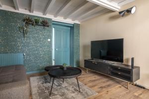 a living room with a couch and a tv and a table at Vienna Antic in Vienne