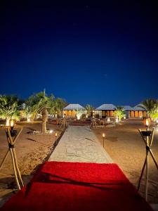 a red carpet on the beach at night at Merzouga Landscape luxury Camp in Merzouga