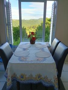 a table with chairs and a tablecloth on it with a window at Refúgio na Serra Gaúcha in Nova Petrópolis