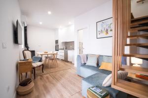 a living room with a blue couch and a table at Portas da Villa in Miranda do Douro