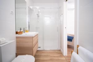 a white bathroom with a shower and a toilet at Portas da Villa in Miranda do Douro +6 photos