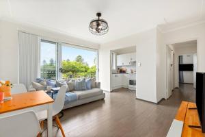 a living room with a couch and a table at Shoreleaf Haven - Moments from Waves & Seaside Eats in Deewhy