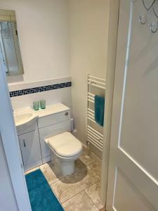a bathroom with a white toilet and a sink at Acorns in Hordle