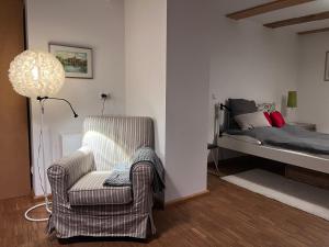 a living room with a chair and a bed at Ferienhaus Früh am See in Fürstenwerder