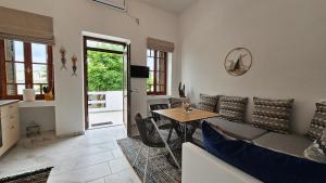 a living room with a couch and a table at Plaka Philoxenia Apartments Milos in Plaka Milou