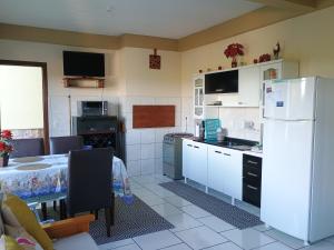 a kitchen with a table and a white refrigerator at Refúgio na Serra Gaúcha in Nova Petrópolis +10 photos
