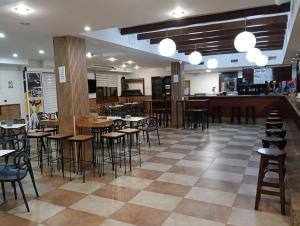 a restaurant with chairs and tables and a bar at Hotel Mesón el 21 in Almería
