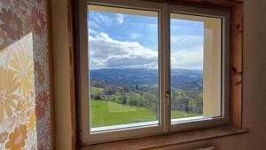 a window with a view of a green field at Passiflore in Saint-Racho