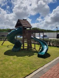 a playground with a slide in a park at PALMARUBA 2bedroom condo in Palm-Eagle Beach