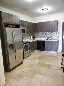 a kitchen with wooden cabinets and stainless steel appliances at PALMARUBA 2bedroom condo in Palm-Eagle Beach