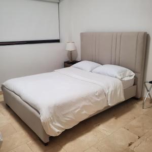 a bedroom with a large bed with white sheets and pillows at PALMARUBA 2bedroom condo in Palm-Eagle Beach +22 photos