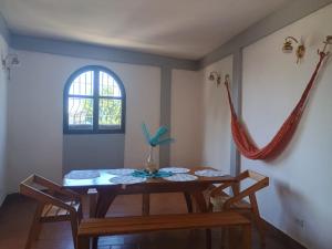 a dining room with a table and a window at Casa Cerdeña in Puerto Carayaca