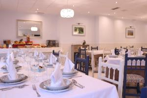 a dining room with white tables and chairs with napkins at El Sueño del Infante in Guadalajara