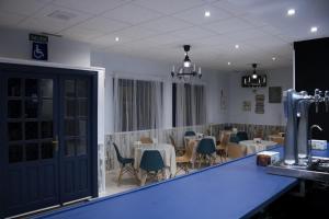 a restaurant with tables and chairs and a blue counter at El Sueño del Infante in Guadalajara
