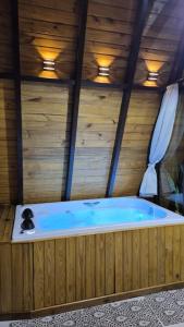 a jacuzzi tub in a room with wooden walls at Chalé a 500 metros do Pico Malwee in Jaraguá do Sul