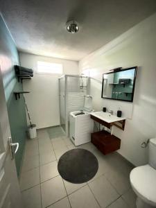 a bathroom with a toilet and a desk and a sink at Sweet Escape in Montjoly
