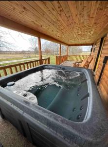 a large hot tub in a porch with a wooden roof at Private Bourbon Cabin in Harrodsburg