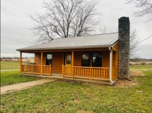 a log cabin with a porch and a chimney at Private Bourbon Cabin in Harrodsburg