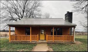 a wooden cabin with a porch and a yellow door at Private Bourbon Cabin in Harrodsburg +20 photos