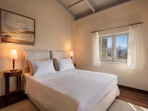 a bedroom with a large white bed with a window at Villa Andromeda in Chania +39 photos
