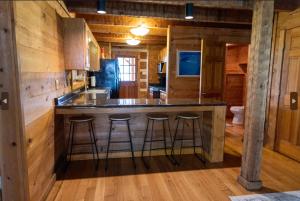 a kitchen with a large island in a log cabin at Governor's Private Cabin on Bourbon Trail w HotTub in Harrodsburg