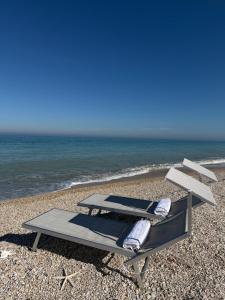 a picnic table and chairs on the beach at La Perla Saba 2 in Montemarciano