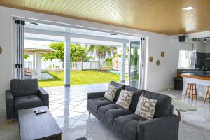 a living room with a couch and a table at 3BR Beachfront Villa Steps from the Lagoon in Paopao