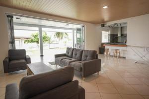 a living room with a couch and chairs and a table at 3BR Beachfront Villa Steps from the Lagoon in Paopao +31 photos