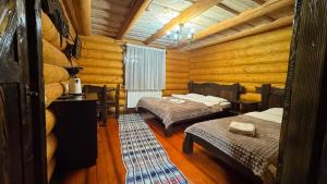 a room with two beds in a log cabin at Hotel Berloga-Sinevir in Synevyrsʼka Polyana