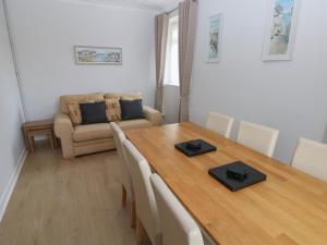 a dining room with a table and a couch at Brynawel in Burry Port +22 photos